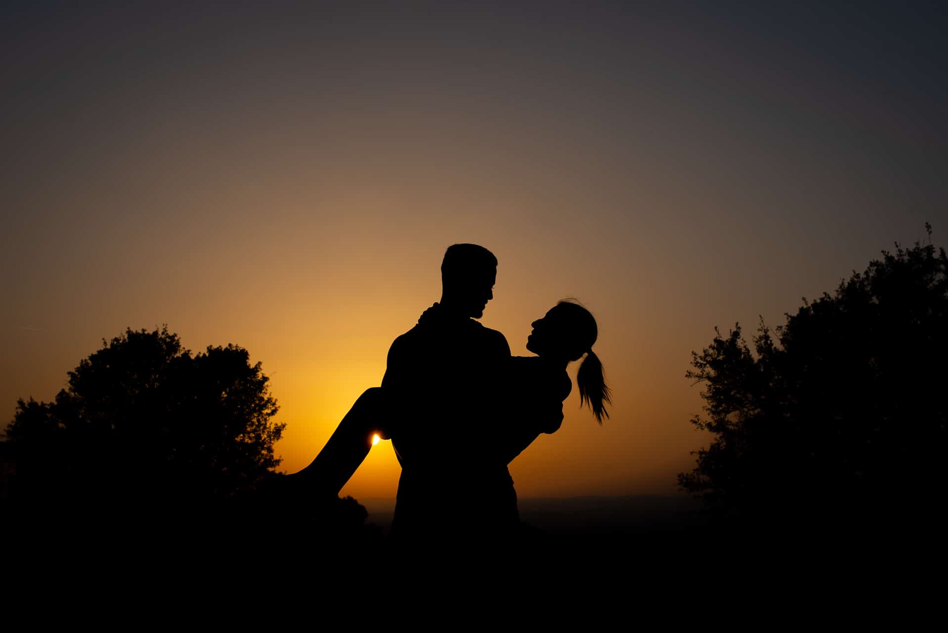 couple bras coucher soleil amoureux