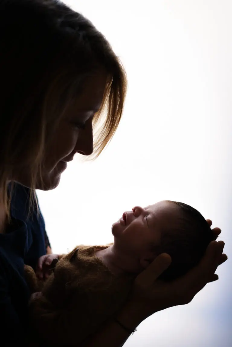 maman avec son bébé qui sourie à contre jour