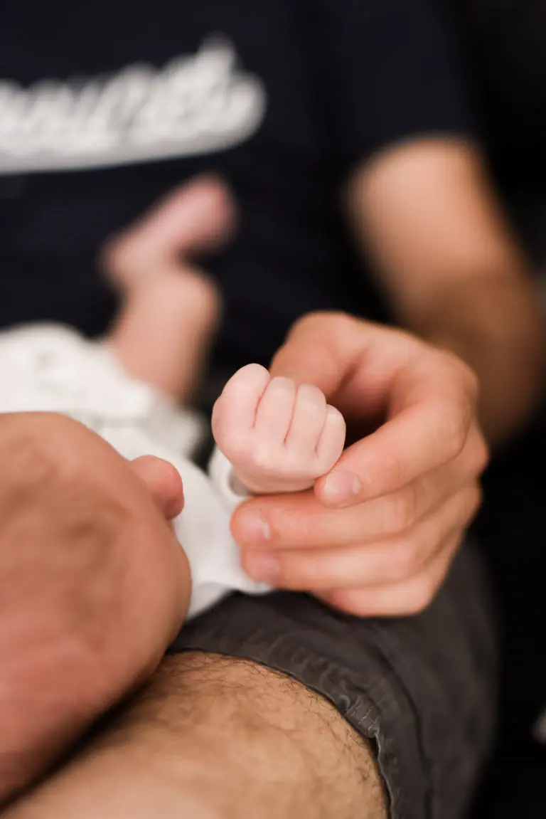 photo de nouveau-né main dans la main avec son papa