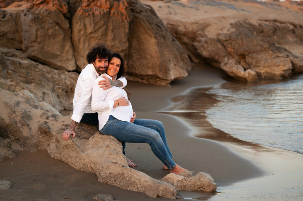 couple sur les rochers sur la plage lors d'une séance photo de grossesse à narbonne par LONOWAÏ Photographie