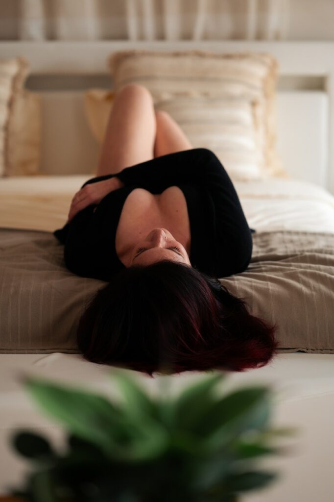 photo d'une femme allongée sur un le dos sur un lit, décolleté et jambes nues visibles. Séannce photo intimiste de femme à narbonne par LONOWAÏ Photographie