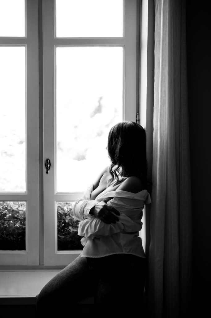 photo d'une femme appuyée contre une fenêtre, jeu de lumière pour mettre en valeur ses courbes. photo boudoir-seflove par LONOWAÏ Photographie à narbonne
