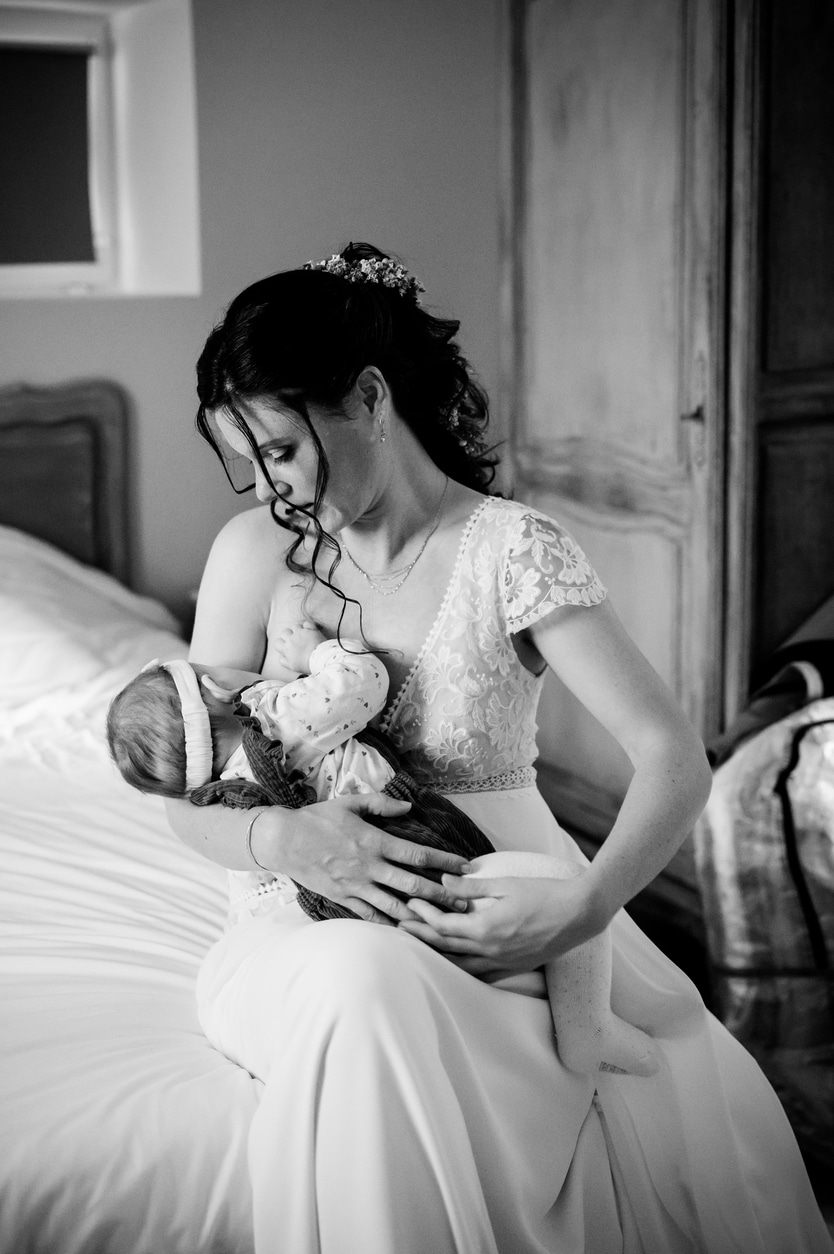 photo d'une mariée qui allaite son bébé dans une chambre à narbonne lors d'une reportage photo de mariage par LONOWAÏ Photographie