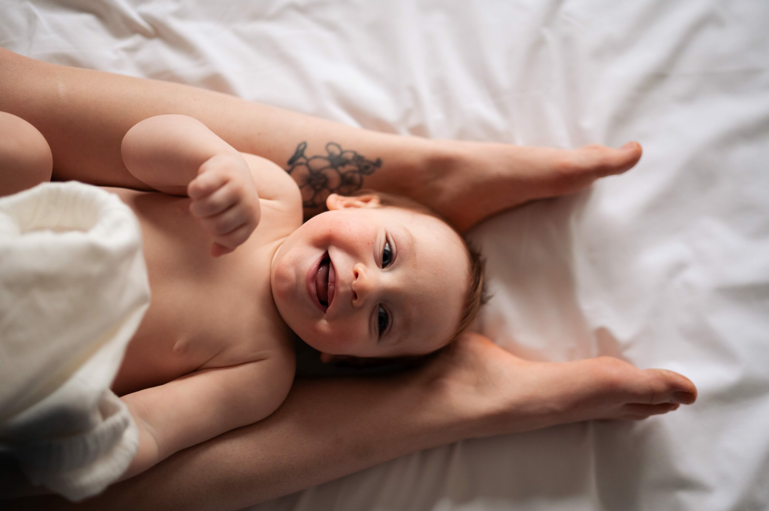 photo d'un bambin allongé sur les jambes de sa mère. séance maternité intimiste à narbonne par LONOWAÏ Photographie